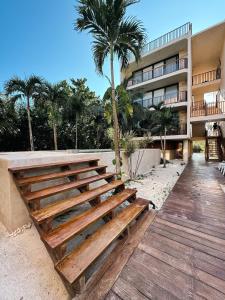 a wooden bench in front of a building at Artistic Loft Steps from the Beach with Pool View in Holbox Island