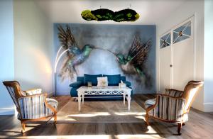 a living room with a blue couch and two chairs at Manoir des Rêves Sauvages in Parentignat