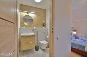 Un baño con lavabo, inodoro y una cama. en Sunset Apartments - Uzdrowiskowa - 200m od plaży!, en Świnoujście 11 fotos más