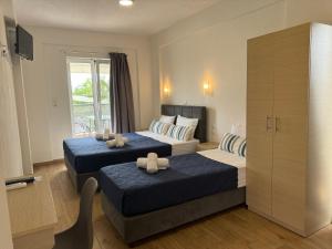 a hotel room with two beds and a tv at Littore Maris in Nea Vrasna +70 photos