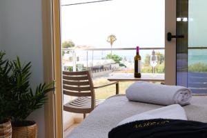 a balcony with a table and a bottle of wine at Ocean View Studios and Luxury Rooms in Plomari