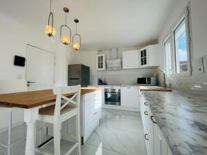 a kitchen with white cabinets and a wooden table at Casa Contemporaine in Angers +27 photos