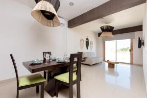 a dining room with a wooden table and chairs at Hotel Kinich in Isla Mujeres