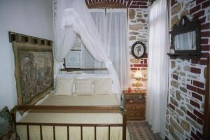 a bedroom with a bed and a window with curtains at Villa Ampanoudi in Katarráktis