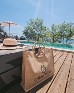 a bag sitting on a deck next to a pool at Olive Villas Beach Hotel in Sozopol