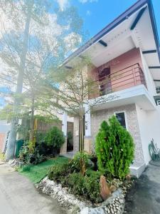a white house with a tree in front of it at Asuncion Staycation and House rental in San Pablo