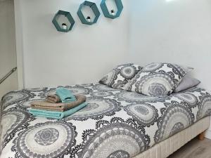 een bed met een zwart-witte deken en kussens bij Centre de Nice : Studio rénové, climatisé et calme in Nice