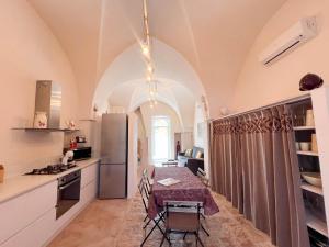 una cocina con una mesa y un refrigerador en TD Torretta Macramè amid the Mediterranean scrub, en Fasano