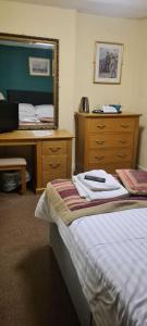 a bedroom with a bed and a desk and a mirror at George & Horn in Kingsclere