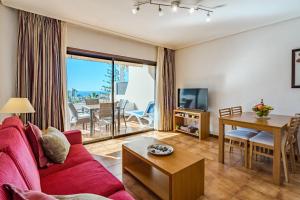 a living room with a red couch and a table at Sea View Albatros Golf del Sur in San Miguel de Abona
