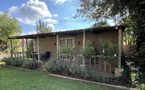 ein kleines Haus mit einem Zaun im Hof in der Unterkunft Heartstone's Rest Cottage in Fouriesburg