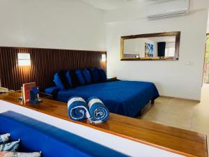 Cette chambre comprend un lit bleu et un miroir. dans l'établissement Palma Real vista al mar, à Manzanillo