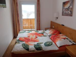 - une chambre avec un lit et une couverture fleurie dans l'établissement Obertauern Fewo Freya by Kamper, à Obertauern