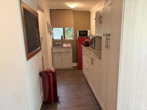 eine Küche mit einem roten Kühlschrank und einem roten Mülleimer in der Unterkunft Heartstone's Rest Cottage in Fouriesburg