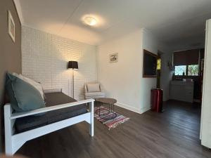 ein Wohnzimmer mit einem Bett und einem Stuhl in der Unterkunft Heartstone's Rest Cottage in Fouriesburg