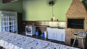 cocina con fogones y chimenea de ladrillo en Chácara do sossego, en Tietê 5 fotos más