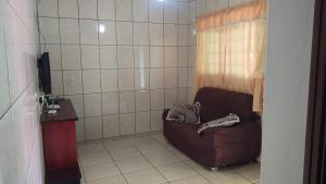 baño con sofá y TV en Chácara do sossego, en Tietê