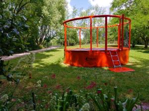 an orange cage in the middle of a grass field at AIRE NATURELLE CAMPING LA LOIRE FLEURIE in Le Perrier