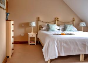 a bedroom with a large white bed with blue pillows at Finest Retreats - Berry Pen Cottage in Kingham +18 photos