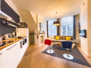 a kitchen and living room with a couch and chairs at Suite aan de A in Groningen