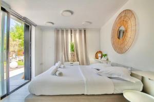 une chambre blanche avec un grand lit et une fenêtre dans l'établissement Maison Design proche gares et centre ville de Lille, à Mons-en-Baroeul