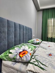 1 cama con cabecero azul y 2 almohadas en Тихий Замок, en Bishkek