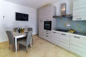 a kitchen with a table and chairs and a stove at Villa Federica by Etra Vacanze in Orosei +14 photos