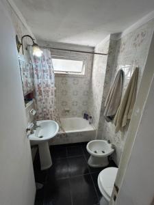 a bathroom with a sink and a toilet and a tub at Departamento a 3 cuadras de la playa in Mar del Plata +4 photos