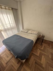 a bed in a room with a wooden floor at Departamento a 3 cuadras de la playa in Mar del Plata