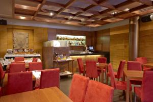 a restaurant with red chairs and tables and a bar at Hotel Sancho Abarca Petit SPA in Huesca