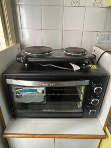 a black toaster oven sitting on top of a counter at Departamento a 3 cuadras de la playa in Mar del Plata