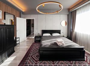 una camera da letto con un letto grande e un lampadario di GreenTeam Apartments a Râmnicu Vâlcea