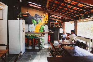 eine Person, die in einem Restaurant an einem Tisch sitzt in der Unterkunft Mahalo Hostel in Abraão
