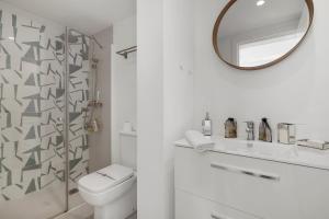 a white bathroom with a toilet and a mirror at Beautiful Family Apartment by Costarentals- Ref 24 in Sitio de Calahonda +10 photos