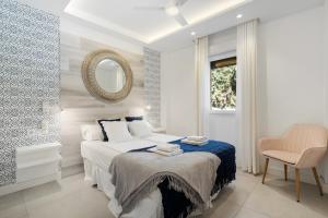 a white bedroom with a bed and a mirror at Beautiful Family Apartment by Costarentals- Ref 24 in Sitio de Calahonda