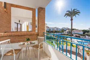 a balcony with a table and chairs and a palm tree at Beautiful Family Apartment by Costarentals- Ref 24 in Sitio de Calahonda