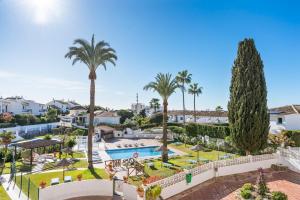 an aerial view of a resort with a swimming pool and palm trees at Beautiful Family Apartment by Costarentals- Ref 24 in Sitio de Calahonda