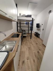 a kitchen with a sink and a wooden floor at apartma Pohorc - Praprot in Pohorje