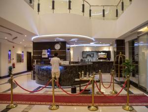a man standing at a counter in a hotel lobby at توارن للشقق المخدومة الاقتصادية in Riyadh