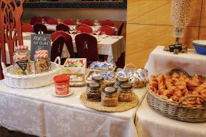 a table with baskets of bread and other food on it at Hotel Sancho Abarca Petit SPA in Huesca