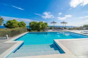 a swimming pool with blue water in a yard at Villa Niki with swimming pool in Kefallonia