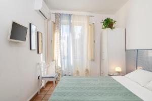 a white bedroom with a bed and a window at Cathedral view apartment in Palermo