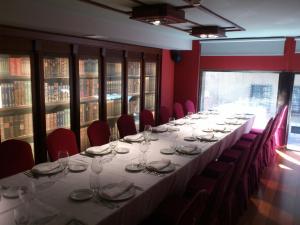 a long table in a room with red chairs at Hotel Sancho Abarca Petit SPA in Huesca