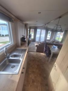 an rv kitchen with a sink and a couch at Beautiful holiday 3 bed Home Camber-sands in Camber