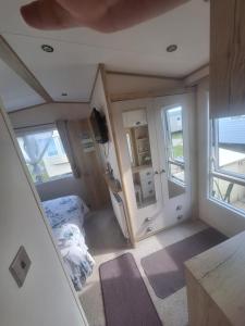 a small room with a bed and a window at Beautiful holiday 3 bed Home Camber-sands in Camber