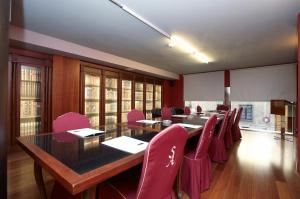 a conference room with a long table and pink chairs at Hotel Sancho Abarca Petit SPA in Huesca