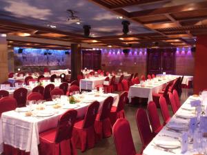 a banquet hall with white tables and red chairs at Hotel Sancho Abarca Petit SPA in Huesca