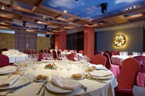 a conference room with white tables and red chairs at Hotel Sancho Abarca Petit SPA in Huesca +37 photos