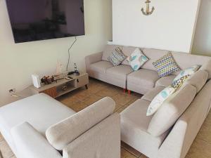 a living room with two couches and a tv at Espectacular Casa de Playa en Asia frente al Mar in Asia