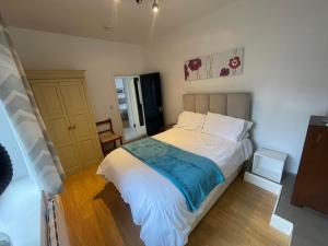a bedroom with a bed with white sheets and blue blanket at Blissful Slumber in Ruskington